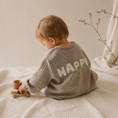 Musselin Hemd für Babys und Kinder. Kind trägt ein Musseline Hemd mit handgenähtem Schriftzug.